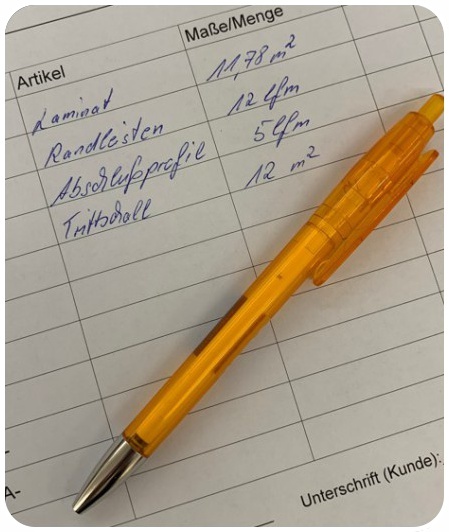 Ausgefüllte Artikelliste mit orangem Kugelschreiber