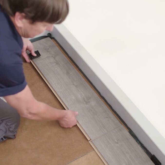 Wie verlegt man Laminat Aufnahme eines Mannes der Laminat verlegt
